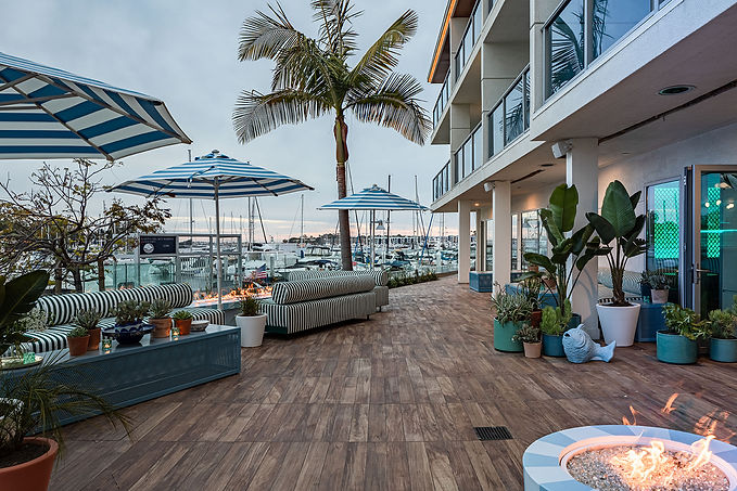SALT Patio with couches, umbrellas, a fire pit and a view of the habor.
